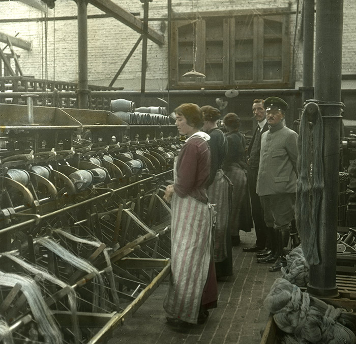 Deutscher Soldat neben Arbeiterinnen in einer Textilfabrik im  belgischen Menen